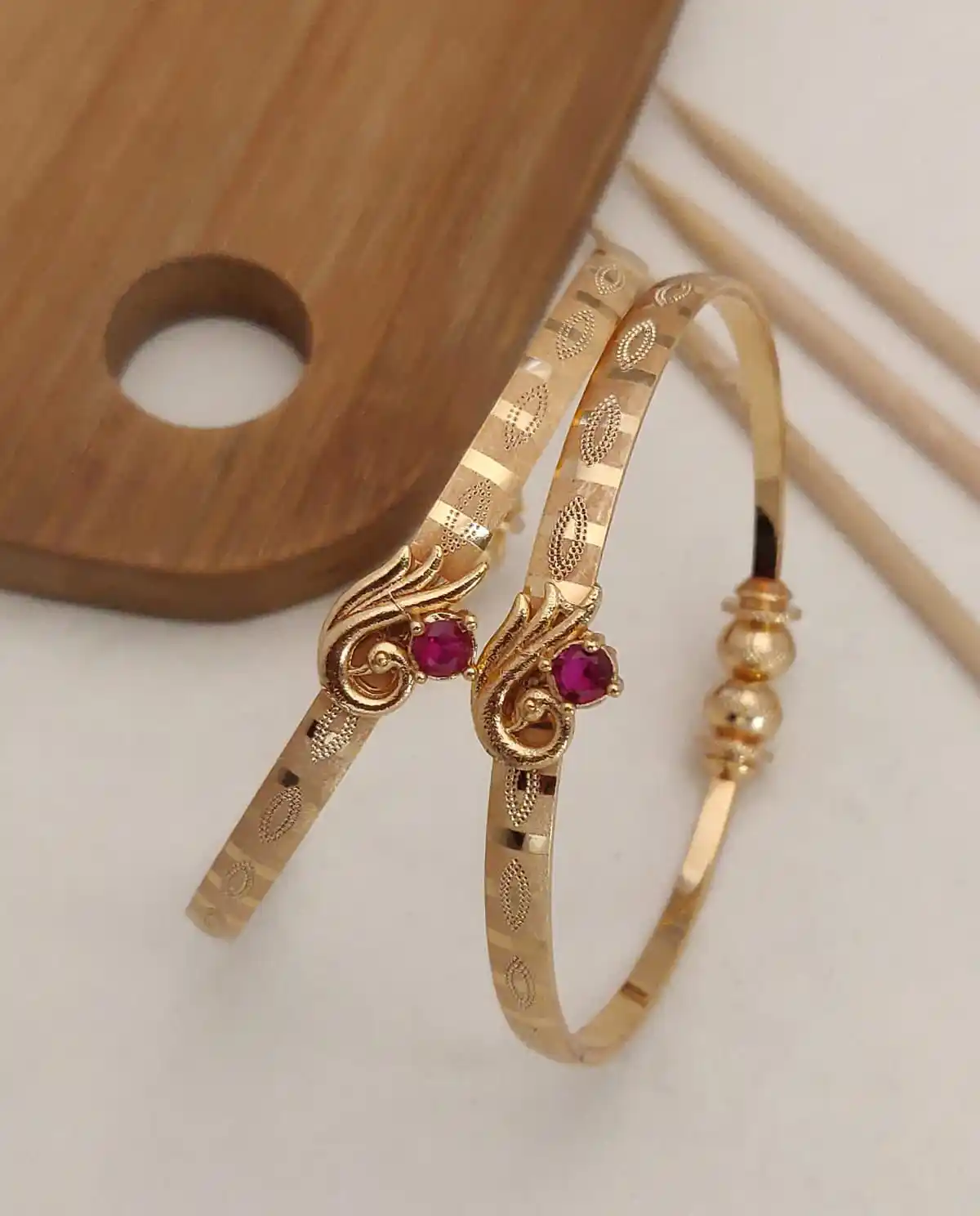 Delicate and elegant gold bangles with a touch of pink.png